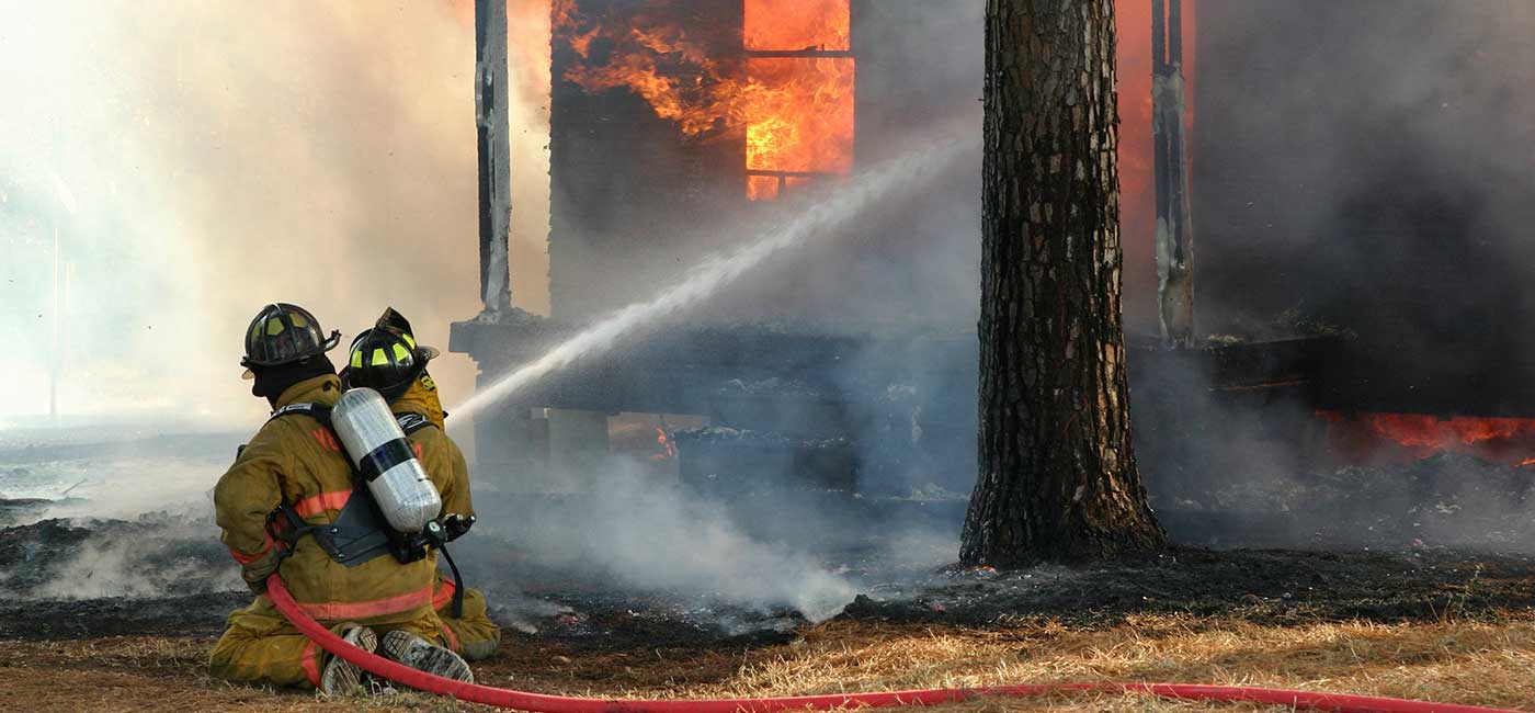 Firefighters spraying burning building